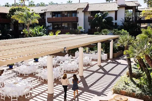 Two people walking past an event venue set up with tables and chairs